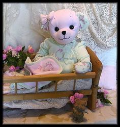 a teddy bear sitting on top of a bed next to pink flowers and other items