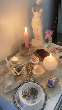 a table topped with plates and candles next to a statue