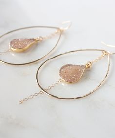 Gold dipped natural druzy drops are the centerpiece of our Large Della Druzy Teardrop Earrings. Suspended by glittering chain inside hand forged gold hoops, the druzy stones shimmer with every movement. Teardrop frames are lightly hammered for a light catching effect. These are stunning statement earrings that your friends will want to borrow!Customize by selecting from one of the multiple druzy stone color options available - see photos for color names. Earrings pictured are in Buff. MATERIALS Indigo Design, Diy Jewlery, Tassel Jewelry, Gold Dipped, Large Earrings, Jewelry Inspo, Top Gifts, Gold Hoops, Gold Filled Jewelry