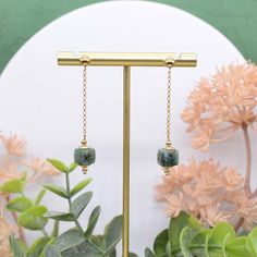 Our Emeralds In Motion earrings are created with one of the world's most precious gemstones, the emerald. Designed with quality in mind and handmade to impress this stunning pair of earrings features faceted, raw emeralds and draped on a shiny pair of 14k gold-filled ball ear posts and sparkly 14k gold-filled rolo chain that beautifully sways and contours the frame of your face with every move. There's something so fun and flirtatious about drape earrings and is a must-have in every jewelry coll Natural Stones Dangle Earrings For May Birthstone, Sterling Silver Faceted Earrings For May Birthstone, Green Faceted Earrings For May Birthstone, Green Faceted Drop Earrings, Faceted May Birthstone Earrings Gift, Dangle Earrings With May Birthstone Gemstone, Single Emerald Earring For May Birthstone, May Birthstone Gemstone Dangle Earrings, May Birthstone Dangle Earrings With Gemstone