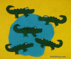 three alligators made out of felt sitting on top of a yellow surface with googly eyes