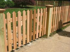 a wooden fence in front of a grassy area