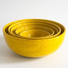 four yellow bowls stacked on top of each other