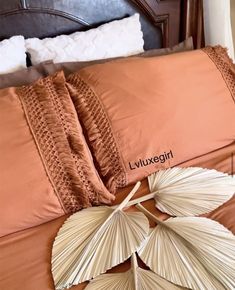 an image of a bed with pillows and decorative items on the headboard in front of it