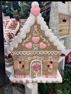 a gingerbread house with pink hearts on it