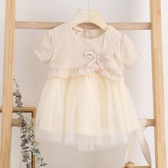 Bowknot Dress for Toddler Girl - PrettyKid Beige Summer Dresses With Bow, Spring Dresses With Bow And Short Sleeves, Beige Half Sleeve Summer Dress, Beige Half-sleeve Summer Dress, Summer Cream Dress With Bow Detail, Cream Spring Dress With Bow, Summer Cream Dress With Bow, Short Sleeve Cotton Dress With Bow, Dress For Toddler Girl