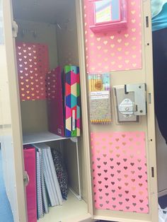 a locker with pink and gold hearts on it's doors is filled with papers