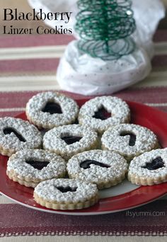 cookies are arranged on a red plate next to a christmas tree