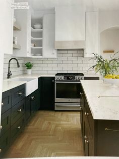 a kitchen with black cabinets and white walls