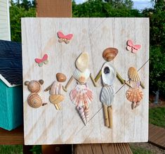 an art piece with shells and seashells painted on the side of a wooden board