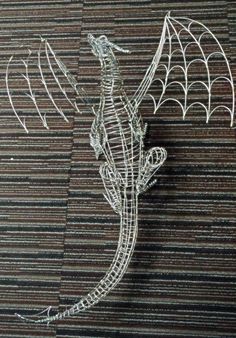 a wire dragon sculpture sitting on top of a table