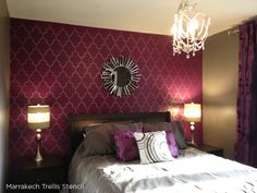 a bedroom decorated in purple and white with a chandelier