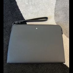 an open laptop computer sitting on top of a carpeted floor next to a black bag