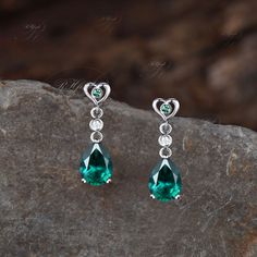 Product Detail Material: 925 Sterling Silver, 10k/14k/18k Solid Rose/White/Yellow Gold, Platinum Quantity: 2pcs (a pair) earrings Center Stone: 6x8mm Pear Cut Lab Emerald Side Stones: Round Cut Lab Emerald and Moissanites Custom Service 1, Gemstones can be replaced with others. 2, All metal can be customized. 3, The earrings can be customized according to the design you want. Please contact us if you need any personalized custom earrings. We will try our best to meet your needs. Only you can't think of it, we can't do it without us. Shipping It's made-to-order jewelry, it will take 2-4 weeks to make it. Once the pendant/necklace is finished, it will be sent by USPS, FedEx or DHL. Return & Refund There is a 30-day return guarantee. But as it's handmade pendant/necklace, handcrafted fee and Pear-shaped Earrings For Anniversary With May Birthstone, Pear-shaped May Birthstone Earrings For Anniversary, Anniversary Pear-shaped May Birthstone Earrings, Teardrop May Birthstone Earrings, Elegant Green Heart Earrings For Gift, Fine Jewelry Anniversary Teardrop Dangle Earrings, Fine Jewelry Teardrop Dangle Earrings For Anniversary, Elegant Gemstone Heart Drop Earrings, Anniversary Fine Jewelry Teardrop Dangle Earrings