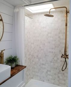 a bathroom with a sink, mirror and shower head on the wall next to it