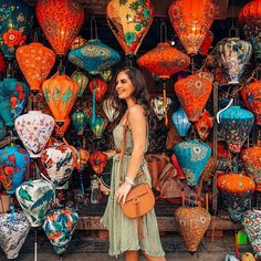 a woman is standing in front of many colorful lanterns