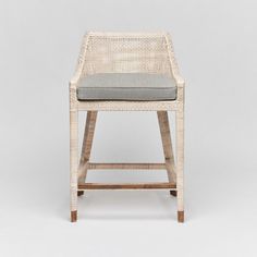 a white wicker bar stool with grey cushion on an isolated gray background, front view