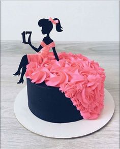 the cake is decorated with pink flowers and an image of a woman holding a book