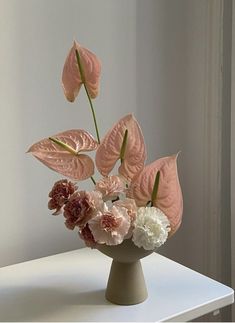 a vase filled with flowers on top of a white table