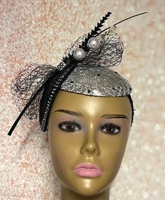 Looking for a head-turner? Look no further. This black and silver piece fits the criteria. Silver mesh fabric on sinamay base then trimmed with rhinestones and a hat pin. The hat pin may vary. Perfect for church and any other special occasions: tea parties, weddings, etc. Simple, yet chic. Length: approximately 9 inches Width: 5.5 inches (at the widest part) The hat pin may vary and is for decorative purposes only. The hat affixes to the head via a hat string. Handmade Gifts for mom, sister, wife, or yourself. PLEASE NOTE All items for Free Shipping will be shipped via USPS First Class Mail. Elegant Black Party Costume Hat, Elegant Black Party Costume Hats And Headpieces, Black Gatsby Style Fascinator For Evening, Black Gatsby Fascinator For Evening, Gatsby Style Black Fascinator For Parties, Black Gatsby Style Fascinator For Party, Black Gatsby Fascinator For Parties, Black Gatsby Style Party Fascinator, Black Gatsby Style Fascinator