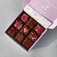 a pink box filled with brownies covered in frosting