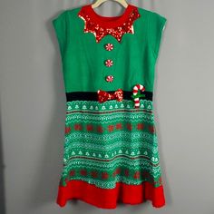 Elf Sweater Short Sleeve Dress With Sequins, Plush Candy Cane Attached And Button Detailing. Style: Ugly Sweater, Holiday, Elf Brand: It's Our Turn Condition: New With Tag Junior's Size: Xl Pit To Pit Approx: 17.5 Inches Length Approx: 32 Inches Material: 85% Acrylic, 15% Polyester Color: Green, Red, White, Black Retail: $58.00 Smoke Free (Inventory: C7) Ugly Christmas Sweater Dress, Elf Dress, Elf Sweater, Christmas Sweater Dress, Christmas Tree Dress, Hoodie Sweater Dress, White Sweater Dress, Santa Dress, Sweater Short Sleeve