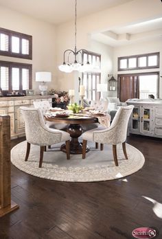 the dining room table is set for four with white chairs and beige upholstered chairs