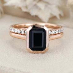 an engagement ring with a black stone surrounded by diamonds