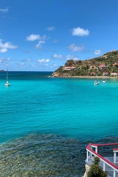 the water is crystal blue and there are boats out in the ocean on this sunny day