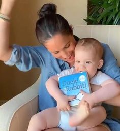 a woman is holding a baby and smiling