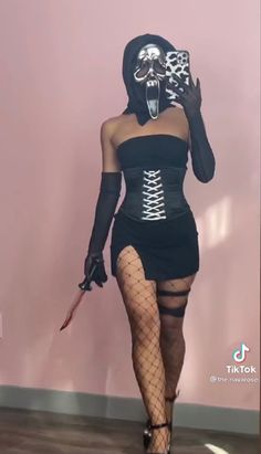 a woman wearing a skeleton mask and fishnet stockings is walking down the runway with a knife in her hand