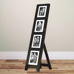 a black and white photo frame sitting on top of a wooden floor next to a wall