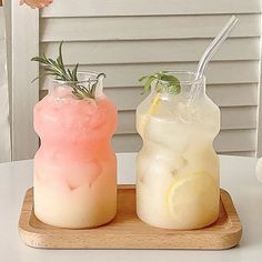 two drinks are sitting on a tray next to each other