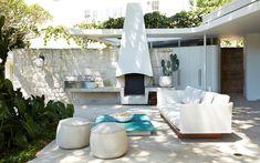 an outdoor living area with white furniture and plants