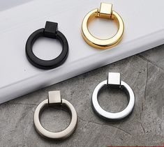 three different colored metal rings sitting on top of a white counter next to each other