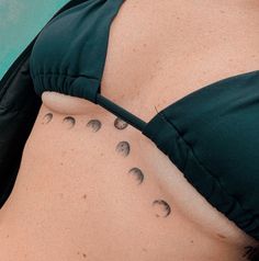 a woman's stomach with phases of the moon on her side, as seen from behind