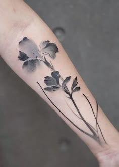 a black and white flower tattoo on the arm