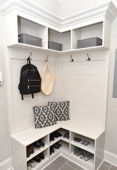 a white bench with some shoes on it and a backpack hanging from the back wall