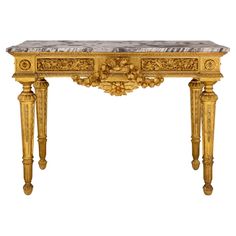 a golden console table with marble top and carvings on the sides, against a white background