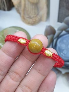 Golden brown Jade bead (13 mm) and a pair of solid 24K Gold Koi fish charms (0.10 - 0.15 gram piece) in this especially handcrafted, adjustable Red Thread bracelet. A pair of white Jade beads (7 mm size) were used for adjusters. All Jade components are Type A natural Jadeite (non -bleached, non-dyed, non-treated materials). Koi fish charms are lightweight, pure Gold (not gold-plated materials). Protection, good luck, good fortune, wealth, prosperity and long life. For customers with much bigger fist and wrist, you can send us a direct message immediately after your payment so we can customized the size before shipping. Hand-strung Jade Bracelet As A Gift, Red Thread Bracelet, Handmade Red Jade Bracelets, Hand-strung Jade Bracelets As Gift, Gold Koi Fish, Hand-strung Jade Bracelets In Gold, Gold Koi, Jade Bracelet Chinese, Thread Bracelet