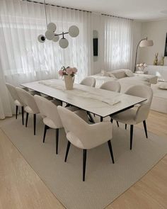 a dining room table with white chairs around it