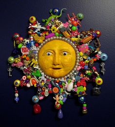 a sun with many different items on it's face and some beads around the eyes