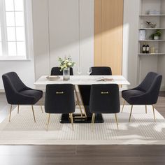 a dining room table with chairs and a rug on the floor