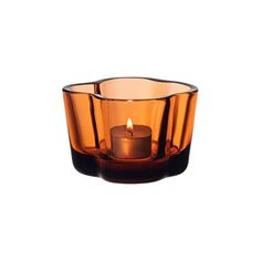 an orange glass candle holder on a white background