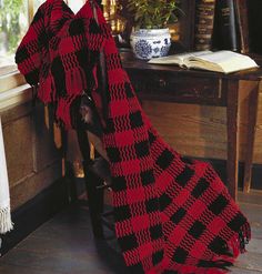 a red and black blanket sitting on top of a chair