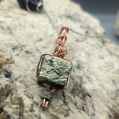 Raw Iron Pyrite Gemstone Pendant - Copper Wire Wrapped, Handmade Energy Stone Necklace, Unique Protective Talisman, Mens Jewelry  Raw Iron Pyrite cube wire wrapped in a braid using copper wire. one of my favorite pieces.  Pyrite is a stone of protection and intellect, enhancing mental clarity and shielding from negative energies.  This handcrafted piece is a beacon of empowerment, designed to accompany you on your journey to success. Artisan Jewelry With Raw Stone For Healing, Artisan Raw Stone Jewelry For Healing, Artisan Jewelry With Raw Stone For Gifting, Artisan Jewelry With Raw Stone For Gift, Wire Wrapped Amulet Jewelry For Meditation, Spiritual Style Copper Jewelry With Raw Stone, Bronze Spiritual Hand Wrapped Necklaces, Spiritual Bronze Hand Wrapped Necklaces, Spiritual Good Luck Rectangular Pendant Jewelry