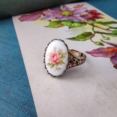 This Victorian vintage style ring is fully adjustable and available in antiqued brass or silver plate. There are two antique porcelain cameo options: Large (18x13mm) or Medium (15x10mm).Don't forget to grab a pair of matching earrings, necklace, or locket from my store to complete the look. Vintage Rose Design Jewelry As A Gift, Vintage Adjustable Cameo Rings, Vintage Enamel Rings For Gifts, Handmade Enamel Vintage Rings, Vintage Cameo Jewelry In Enamel, Vintage Cameo Enamel Jewelry, Vintage Oval Jewelry With Rose Design, Vintage Enamel Cameo Jewelry, Handmade Vintage Enamel Ring For Anniversary