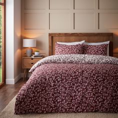 a bed with red and white bedspread in a bedroom next to a window