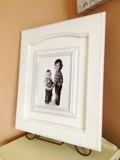 a white frame holds a black and white photo of two children