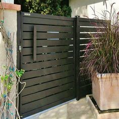 a tall planter sitting next to a wooden gate